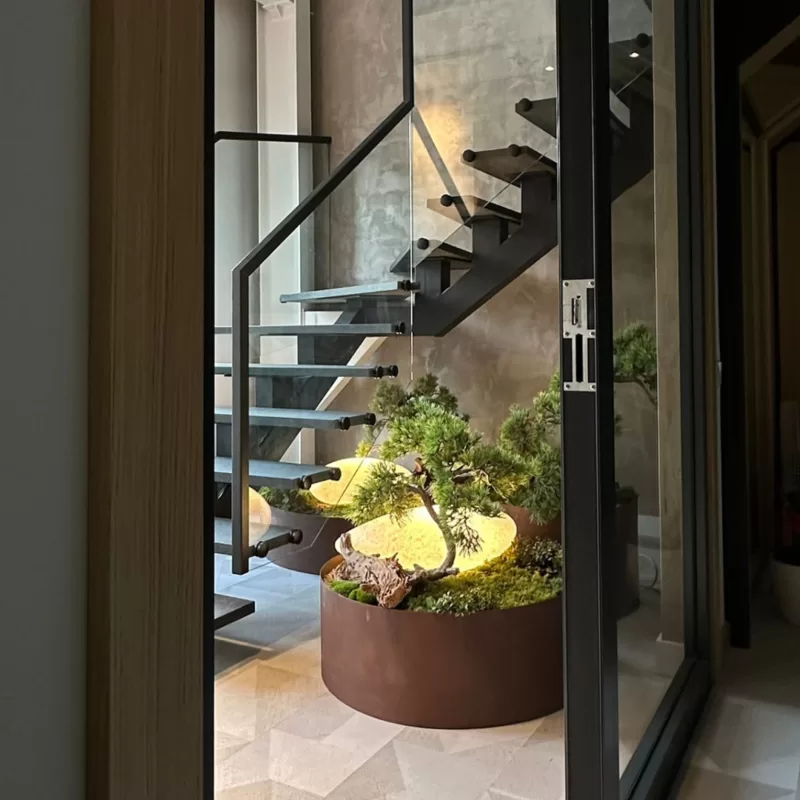 Interjera noformējums ar augu kompozīciju pie kāpnēm